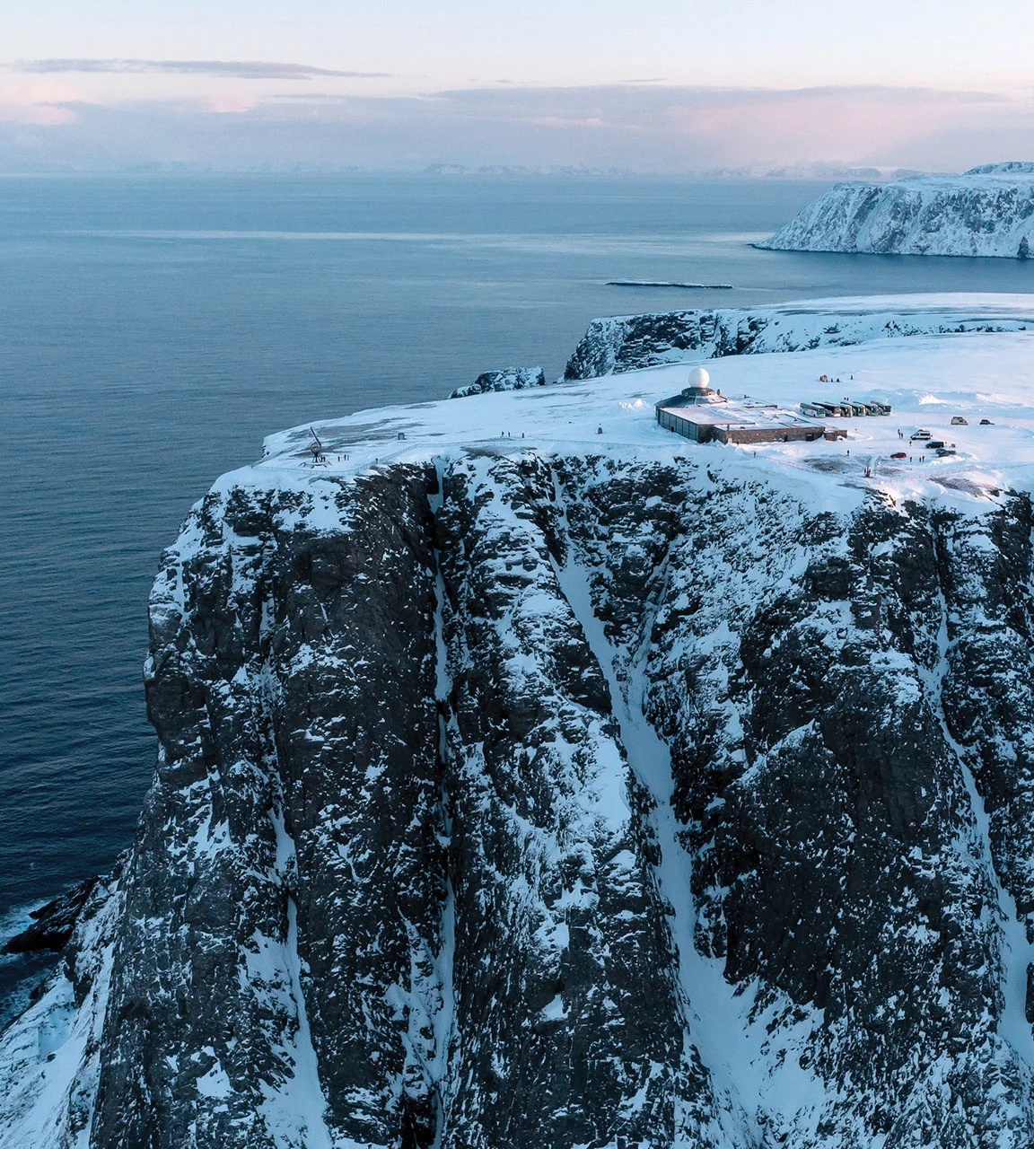 The snow-covered North Cape cliff above the Arctic Ocean in winter light