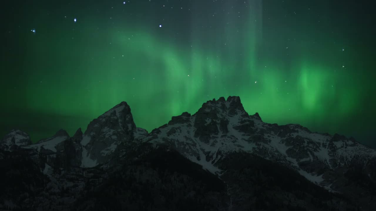 The aurora borealis over snow-covered peaks, the first frame of the aurora film