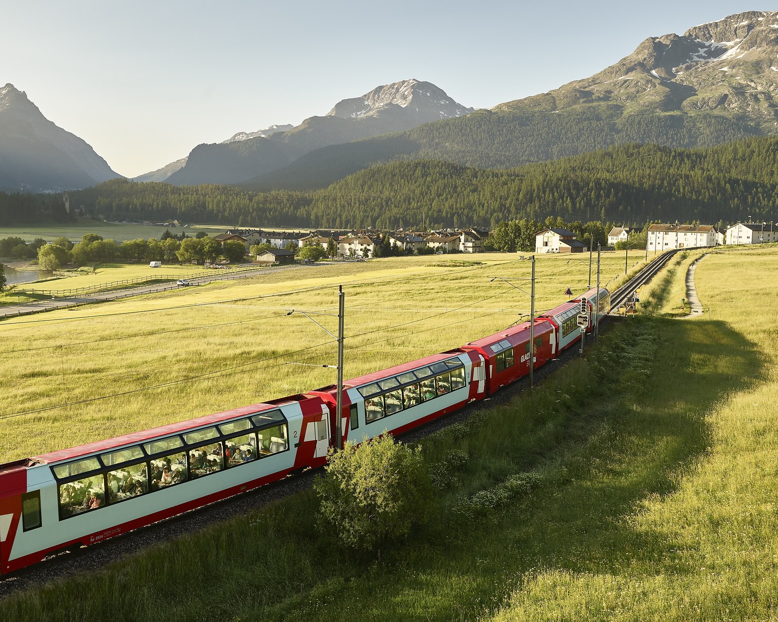 The Glacier Express running through the Engadin meadows in summer