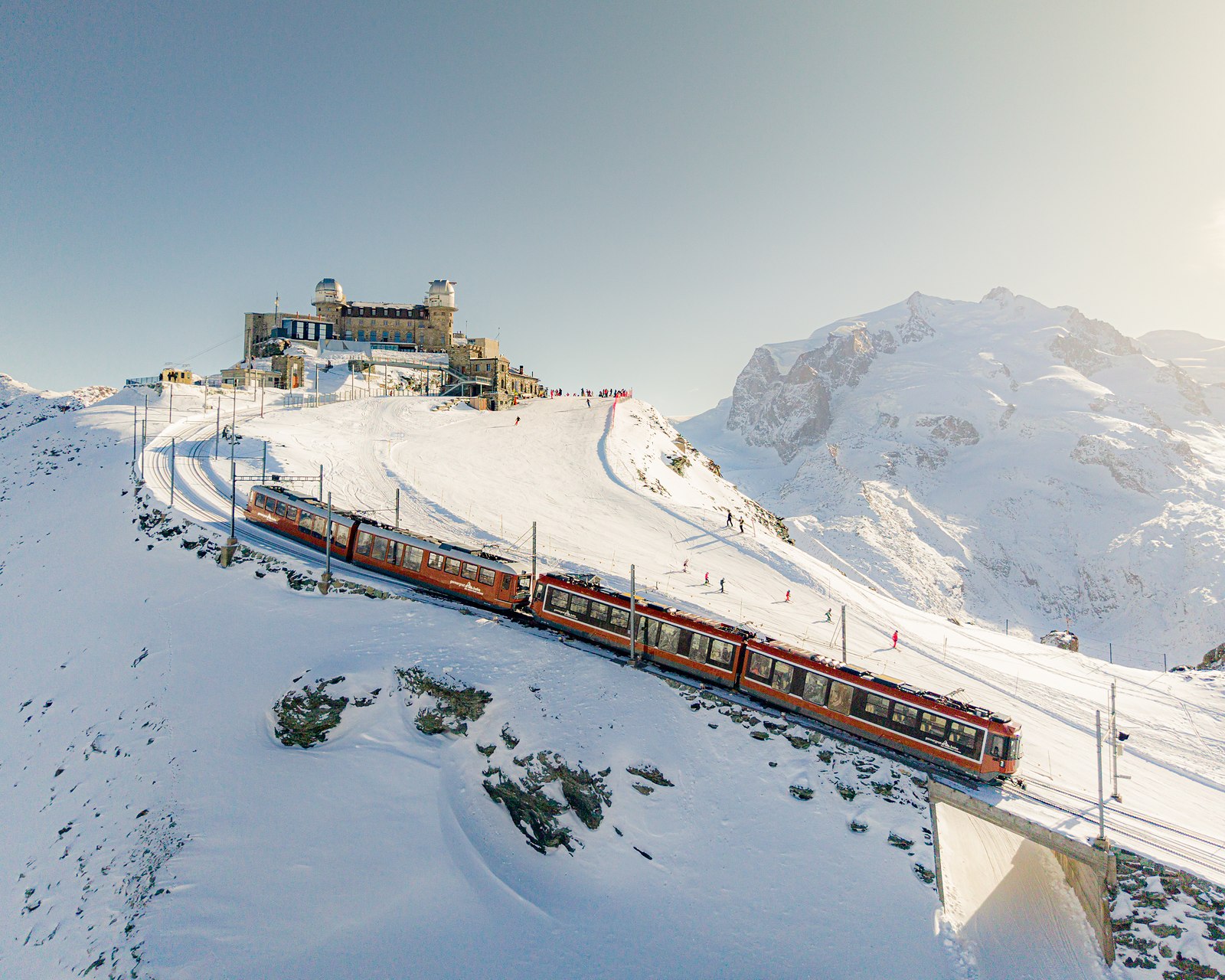 The Gornergrat railway arriving at the summit station in winter, Monte Rosa behind